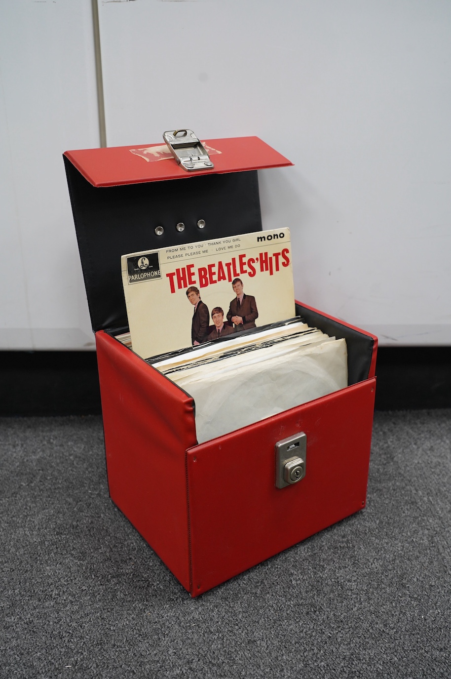 Fifty The Beatles and related 7” singles all on Apple or Parlophone labels, some with picture covers, contained within a singles carry case. Condition - fair